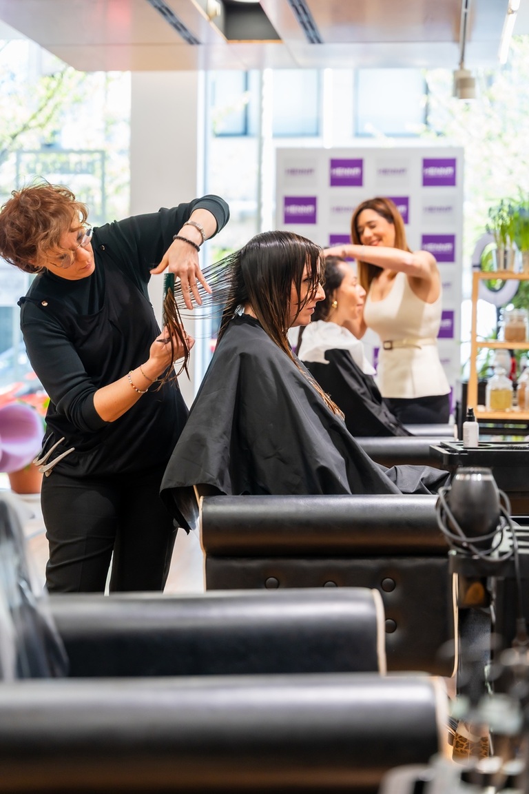 Friseurin schneidet einer Kundin im Salon die Haare